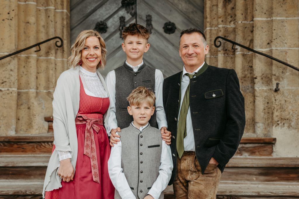 Familie in Tracht vor steinernem Gebäude
